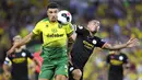 Pemain Norwich City, Ben Godfrey, berebut bola dengan striker Manchester City, Gabriel Jesus, pada laga Premier League di Stadion Carrow Road, Sabtu (14/9). Norwich City menang 3-2 atas Manchester City. (AP/Joe Giddens)