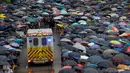 Pengunjuk rasa memberi ruang bagi ambulans yang melintas saat demonstrasi di Hong Kong, Minggu (18/8/2019). Puluhan ribu massa pro-demokrasi membawa payung saat hujan mengguyur Victoria Park dan sekitarnya. (AP Photo/Vincent Thian)
