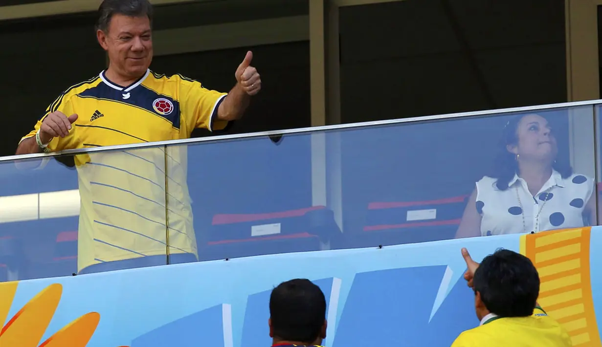 Presiden Kolombia, Juan Manuel Santos, menyambut acungan jempol dari salah satu penonton laga babak penyisihan Piala Dunia 2014 Grup C di Stadion National Mane Garrincha, Brasil, (19/6/2014).(REUTERS/Paul Hanna)
