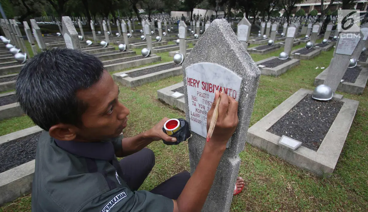 Pekerja saat mengecat nisan di Taman Makam Pahlawan Kalibata di Jakarta, Kamis (9/11). Pembersihan tersebut dilakukan guna menyambut Hari Pahlawan yang diperingati setiap 10 November. (Liputan6.com/Immanuel Antonius)