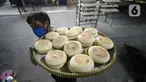 Pekerja membawa kue bulan di Industri Rumahan Kue Bulan Putri Lauw, Pondok Sentul, Ciater, Tangerang Selatan, Selasa (10/11/2020). Pada masa pandemi sekarang, produksi kue tradisional khas Tionghoa tersebut menurun sesuai pesanan pembeli. (merdeka.com/Dwi Narwoko)
