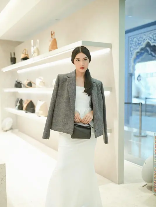 Di potret ini, Anissa kenakan strapless dress dengan rok mermaid putih dan blazer abu-abu. Mini Puzzle Bag dari Loewe jadi aksen yang netral. [@anissaazizah]