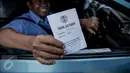 Pengendara menunjukan kartu hasil uji emisi usai melakukan uji emisi kendaraannya di kawasan Tugu Proklamasi, Jakarta, Selasa (16/5). Sudin Lingkungan Hidup Jakarta Pusat menggelar uji emisi guna menekan angka polusi kendaraan (Liputan6.com/Faizal Fanani)