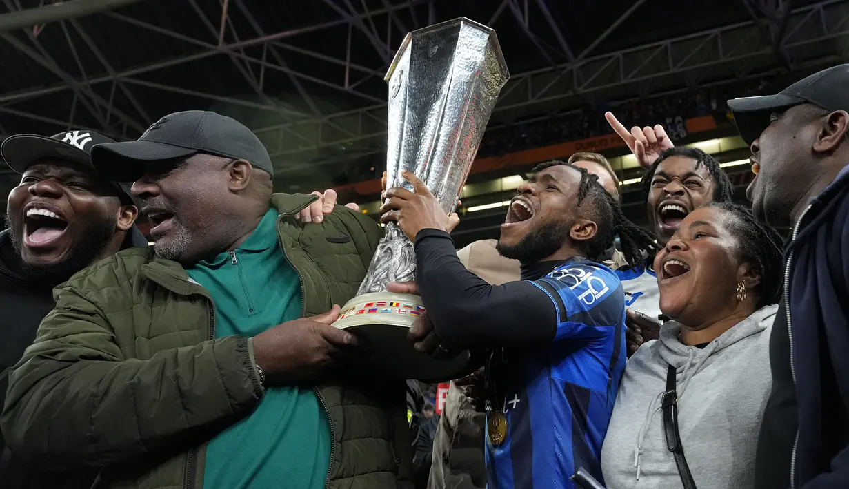 Pemain Atalanta, Ademola Lookman bersama keluarganya merayakan gelar juara Liga Europa 2023/2024 setelah berhasil menang pada laga final melawan Bayer Leverkusen di Dublin Arena, Irlandia, Kamis (23/05/2024) dini hari WIB. (AP Photo/Kirsty Wigglesworth)