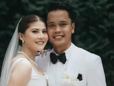 Anthony Ginting dan Mitzi Abigail elegan dengan busana warna putih. Busana yang dipilih oleh pasangan ini cocok dengan konsep pernikahan semi outdoor keduanya yang digelar di Hotel Amaryllis. Gaun Mitzi Abigail ini merupakan rancangan desainer Elsie Chrysila Atelier, sementara setelan jas Anthony Ginting adalah rancangan desainer ternama Jonathan Wongso. (Liputan6.com/IG/@sinisukanthony)