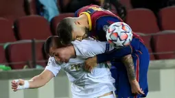 Bek Barcelona, Gerard Pique, berebut bola dengan gelandang Ferencvaros, Oleksandr Zubkov, pada matchday 1 Grup G Liga Champions 2020/2021 di Camp Nou, Rabu (21/10/2020) dini hari WIB. Barcelona menang 5-1 atas Ferencvaros. (AFP/Lluis Gene)