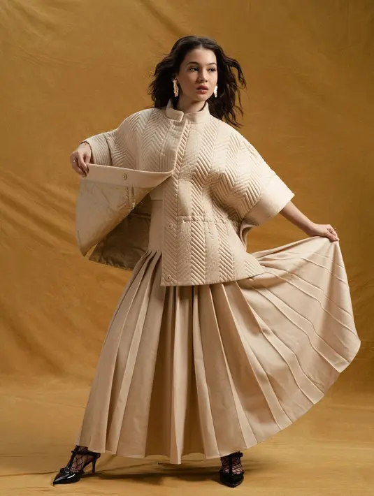 Sandrinna Michelle memesona dengan outfit serba cokelat dari Gucci. Ia mengenakan oversized top dipadu dengan maxi pleated skirt yang serasi. [Foto: Instagram/winstongomez]