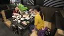 Pelanggan duduk bersebelahan dengan boneka kartun naga yang digunakan restoran untuk menjaga jarak fisik di Bangkok, Thailand, Senin (18/5/2020). Pemerintah Thailand mengizinkan pusat perbelanjaan dan bisnis kembali dibuka setelah sebelumnya ditutup karena pandemi COVID-19. (AP Photo/Sakchai Lalit)