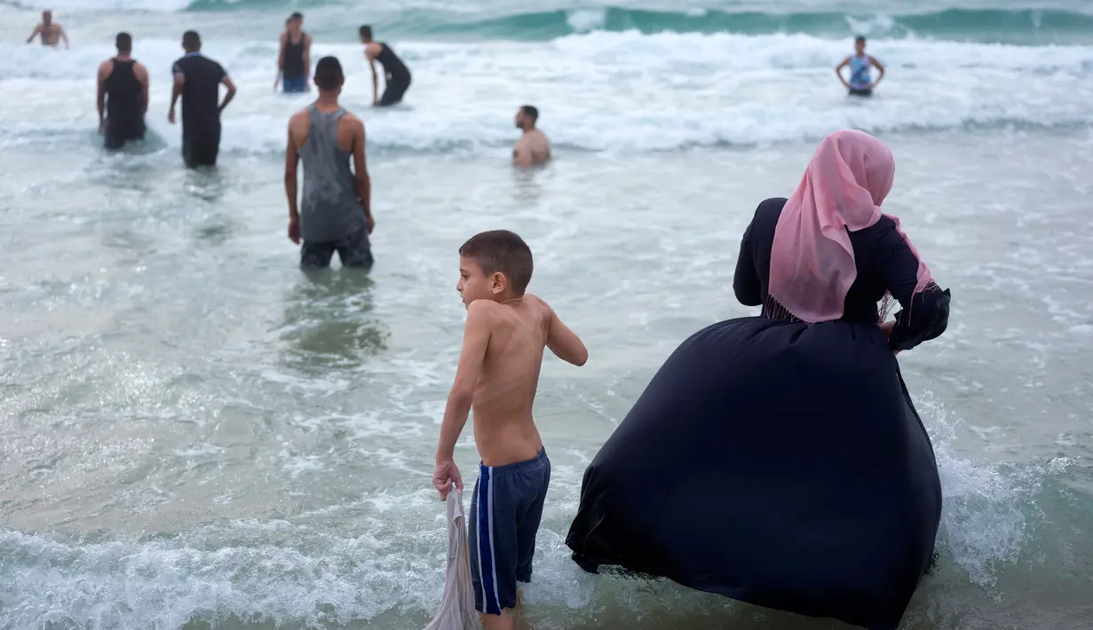 Muslim Palestina bermain dan berenang saat menghabiskan hari libur Lebaran di pantai Tel Aviv, Israel, 6 Juni 2019. Selama Idul Fitri, warga Palestina mengunjungi pantai di kawasan Tel Aviv untuk menandai berakhirnya ibadah puasa Ramadan. (AP Photo/Oded