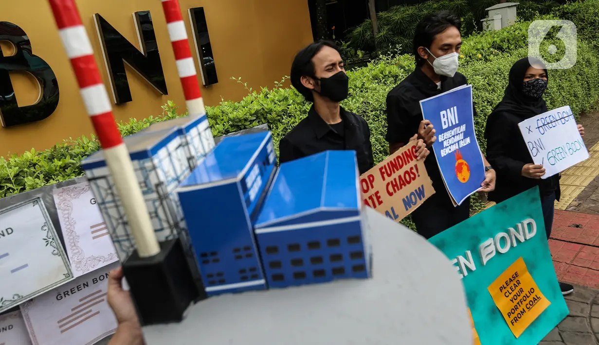 Aktivis yang tergabung dalam kampanye #bersihkanbankmu membawa poster saat aksi di depan kantor Bank Tabungan Negara (BNI), Jakarta, Jumat (17/6/2022). Dalam aksinya mereka mempertanyakan keseriusan Bank BI dalam penghentian pembiayaan proyek batu bara dan menyerukan untuk menghentikan praktek Greenwashing. (Liputan6.com/Johan Tallo)
