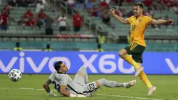 Pemain Wales Aaron Ramsey (kanan) mencetak gol ke gawang Turki yang dijaga Ugurcan Cakir pada pertandingan Grup A Euro 2020 di Stadion Olimpiade Baku, Baku, Azerbaijan, 16 Juni 2021. Memanfaatkan umpan manja Gareth Bale, Aaron Ramsey mencetak gol yang sangat berkelas. (Naomi Baker/Pool via AP)