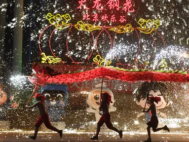 Penari melakukan tarian naga di sebuah taman pada hari keempat Tahun Baru Imlek di Beijing (8/2). China menandai kedatangan Tahun Babi dengan liburan Festival Musim Semi selama seminggu.  (AFP Photo/Greg Baker)