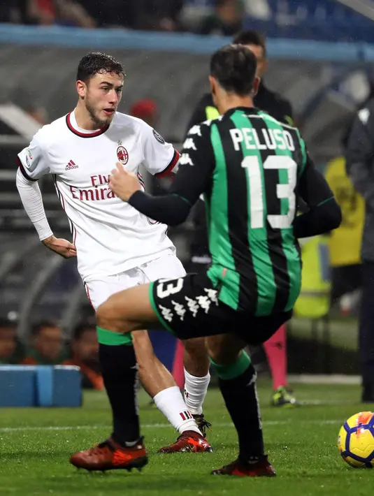 Bek AC Milan, Davide Calabria berusaha mengumpan bola dari kawalan Federico Peluso saat bertanding pada lanjutan Liga Serie A Italia di Stadion Mapei. Reggio Emilia (5/11). Milan menang 2-0 atas Sassuolo. (Elisabetta Baracchi / ANSA via AP)