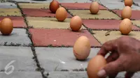 Telur ayam berdiri sendiri pada perayaan Peh Cun di Pasar Lama, Kota Tangerang, (9/6). Fenomena ini akibat posisi matahari berada pada titik kulminasi terdekat dengan bumi sehingga pengaruh gravitasi terhadap bumi lebih kuat. (Liputan6.com/Fery Pradolo)