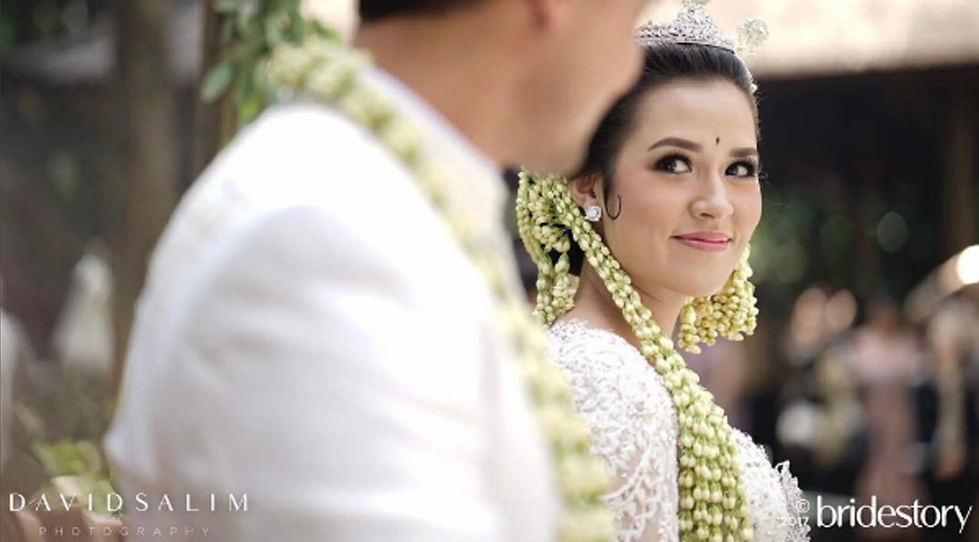 Penyanyi Raisa tersenyum dihadapan sang suami Hamish Daud usai melangsungkan akad nikah. (Instagram/thebridestory)