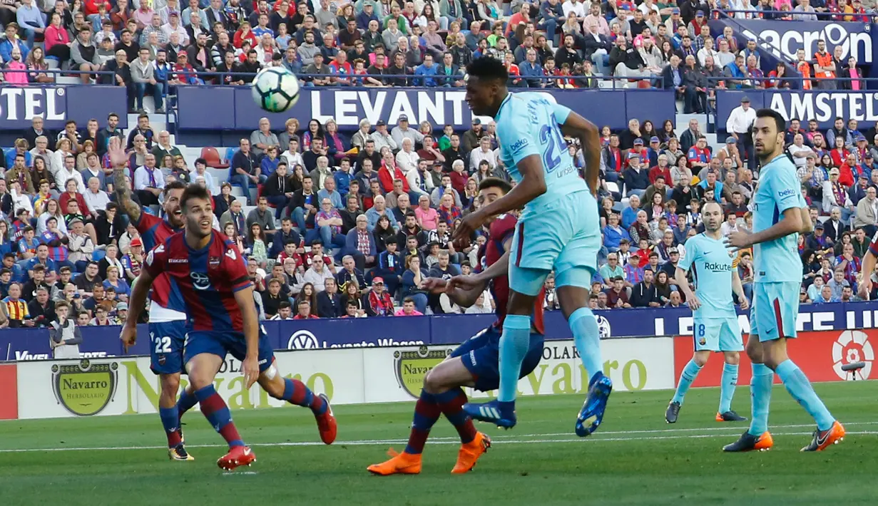Pemain Barcelona Yerry Mina melompat untuk menyundul bola pada jornada ke-37 La Liga melawan Levante di Estadio Ciudad de Valencia, Senin (14/5). Barcelona gagal menjaga rekor tak terkalahkan musim ini pada ajang La Liga Spanyol (AP/Alberto Saiz)