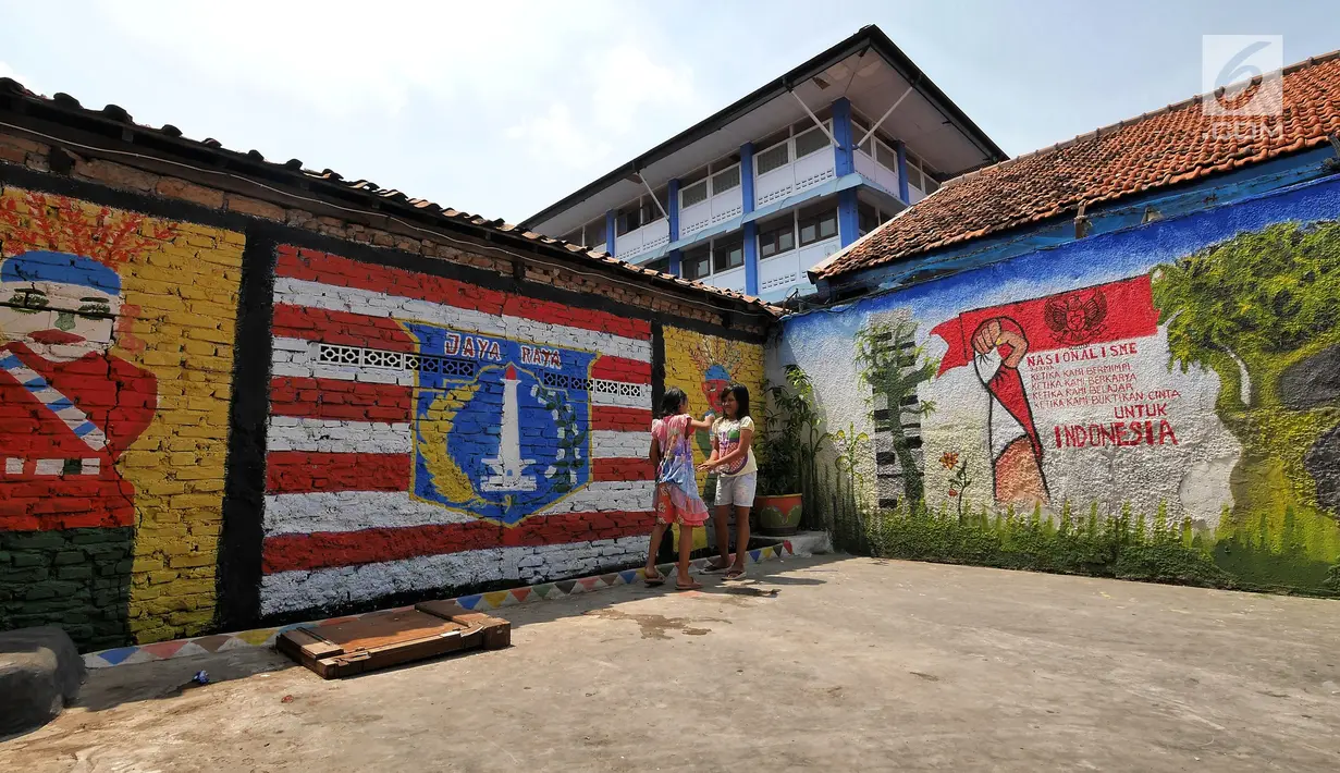 Dua anak bermain di samping sisi tembok warga yang dindingnya dihiasi lukisan mural penuh warna di Kampung Pejaten, Jakarta, Senin (30/4). Mural motif warna-warni itu digagas warga untuk memperindah kampung mereka. (Liputan6.com/Herman Zakharia)