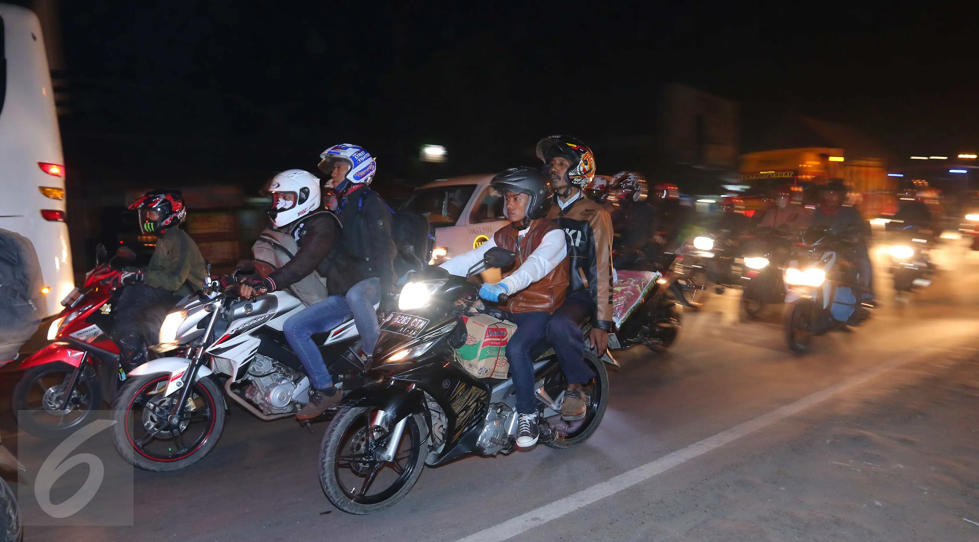 Sejumlah pemudik sepeda motor melintasi jalur simpang Cikalong, Jawa Barat, Jumat (1/7) dini hari. H-5 Lebaran, ratusan pemudik yang menggunakan sepeda motor mulai memadati jalur pantura menuju Jawa Tengah. (Liputan6.com/Angga Yuniar)