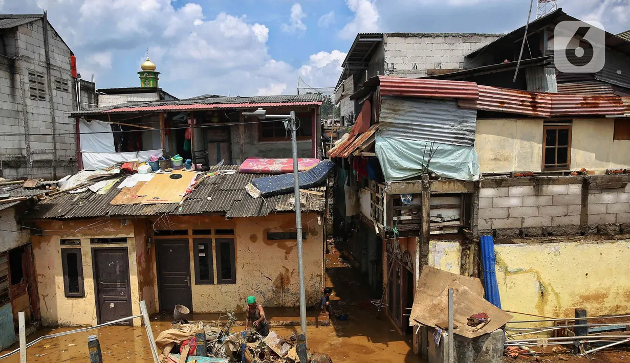 Usai terendam banjir, sejumlah warga mulai sibuk membersihkan rumah mereka dari endapan lumpur serta sisa sampah yang terbawa arus banjir. (Liputan6.com/Angga Yuniar)