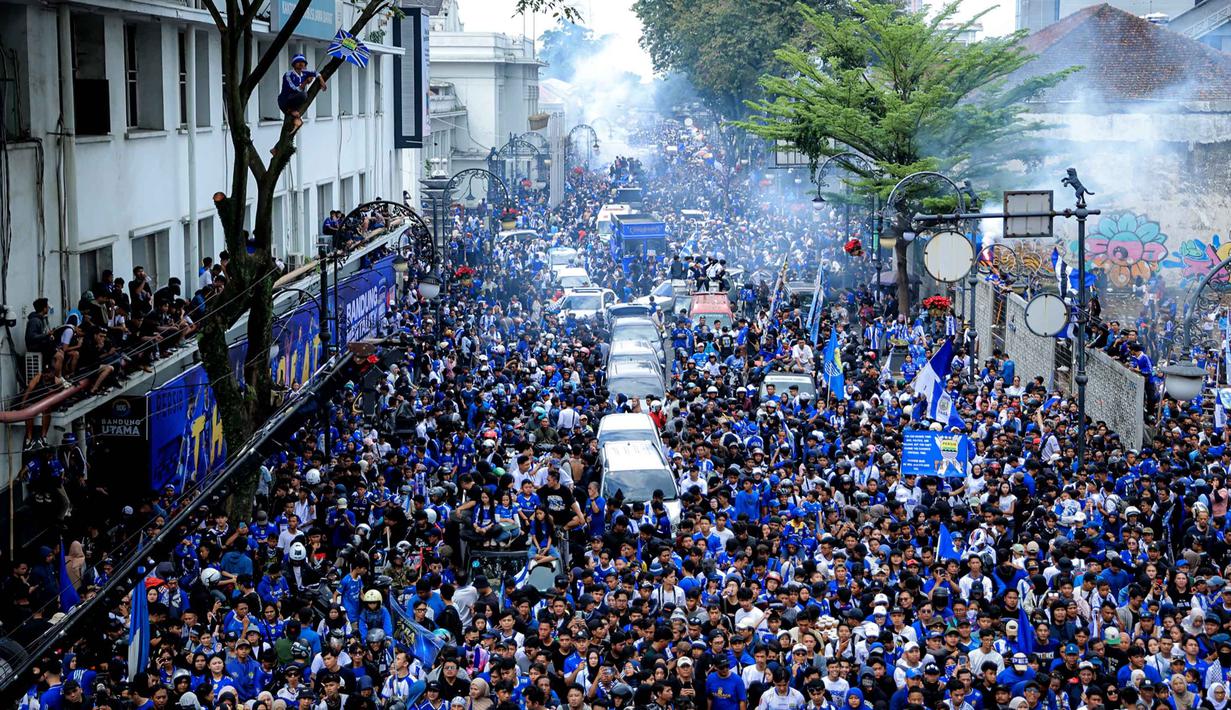 Warga menyambut tim dan ofisial Persib Bandung saat pawai perayaan gelar juara BRI Super League 2025/2026 di Bandung, Jawa Barat, Minggu (24/5/2026). (Bola.com/Bagaskara Lazuardi)