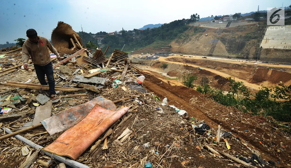Warga berjalan melintasi puing-puing rumah yang terkena proyek pembangunan Bendungan Ciawi di Desa Gadog, Bogor, Jawa Barat, Kamis (22/08/2019). Bendungan Ciawi memiliki luas 31,96 hektare. (Merdeka.com/Arie Basuki)