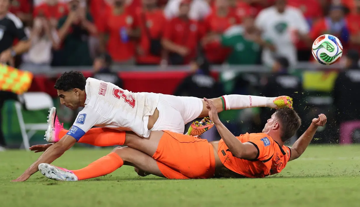 Pemain Maroko Achraf Hakimi terjatuh setelah pemain belanda Micky van de Ven (melakukan tekel di depan gawang selama pertandingan sepak bola babak 32 Piala Dunia antara Belanda dan Maroko di Guadalupe, dekat Monterrey, Meksiko, Senin (29/06/2026). (AP Photo/Addison Simmons)