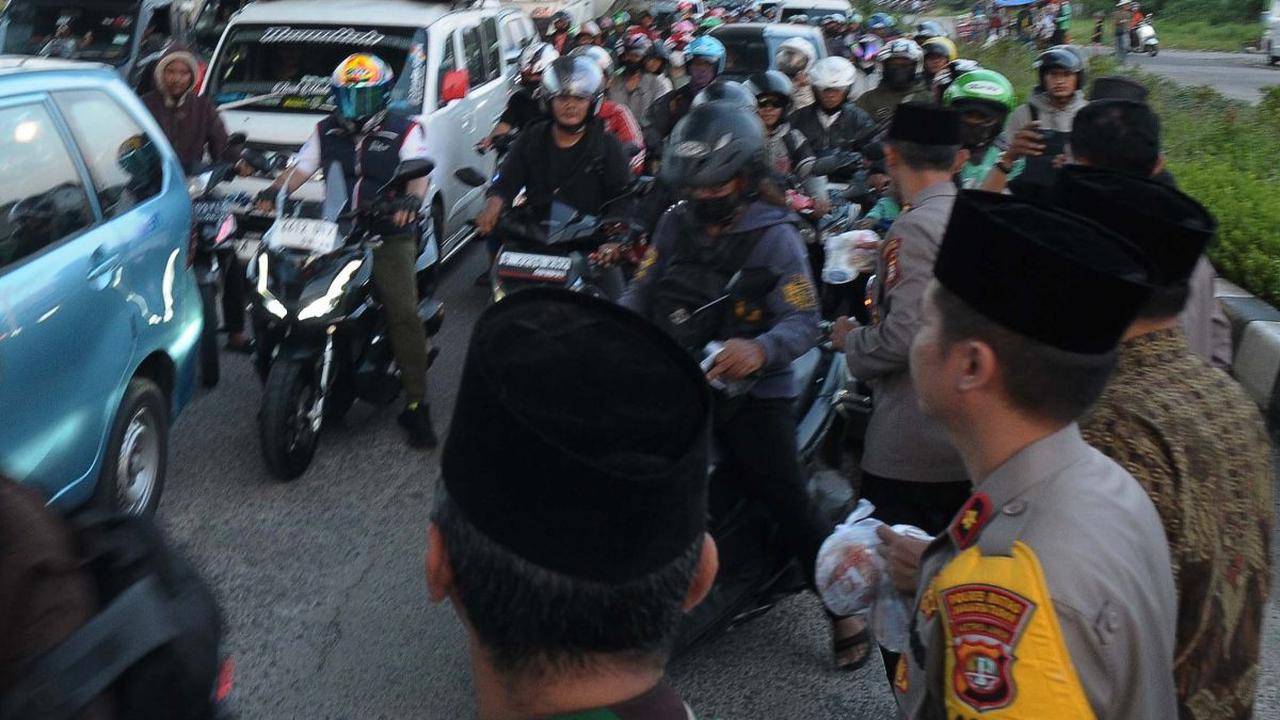 Sejumlah prajurit TNI dan petugas kepolisian dari Polsek Cakung membagikan takjil gratis kepada warga yang melintas di Jalan Raya Cakung, Jakarta Timur, Kamis (21/3/2024). Ada 300 paket takjil yang dibagikan gratis&nbsp;menjelang waktu berbuka puasa.&nbsp