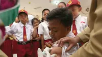 Siswa SD saat disuntik imunisasi difteri di sebuah sekolah dasar di Tangerang,  Senin (11/12). Indonesia memulai sebuah kampanye untuk mengimunisasi 8 juta anak-anak dan remaja dari difteri. (AP Photo / Tatan Syuflana)