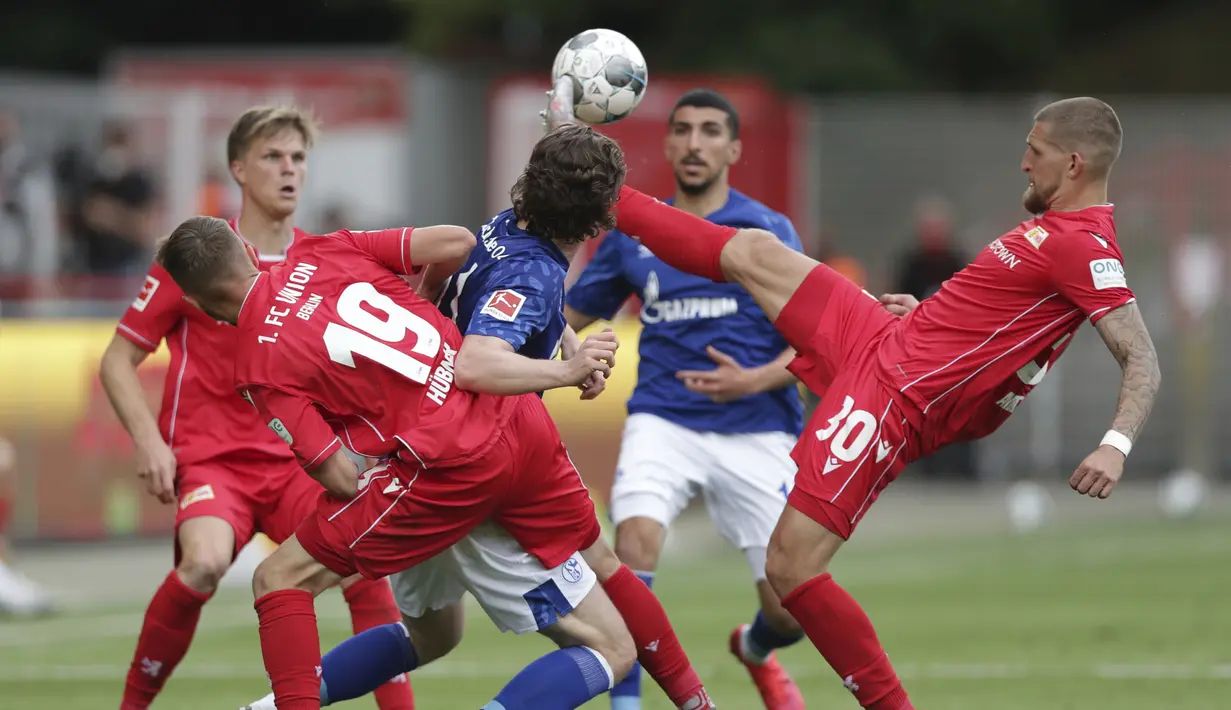 Pemain Union Berlin, Robert Andrich, berebut bola dengan pemain Schalke pada laga Bundesliga di Weserstadion Minggu (7/6/2020). Kedua tim bermain imbang 1-1. (AP/Michael Sohn)