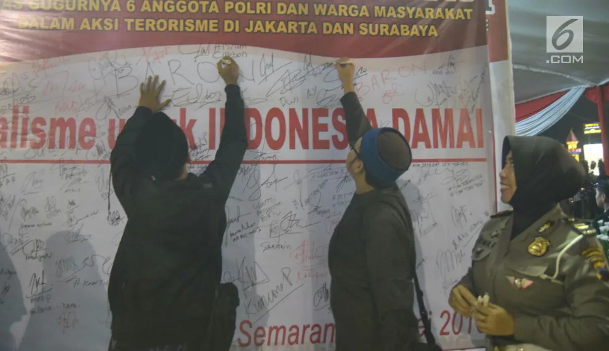 Sejumlah warga menandatangani spanduk saat tablig akbar di Simpang Lima, Kota Semarang, Minggu (13/5). Spanduk tersebut bentuk dukacita untuk korban teror di Mako Brimob, Jakarta beberapa waktu lalu dan teror bom gereja di Surabaya. (Liputan6.com/Gholib)