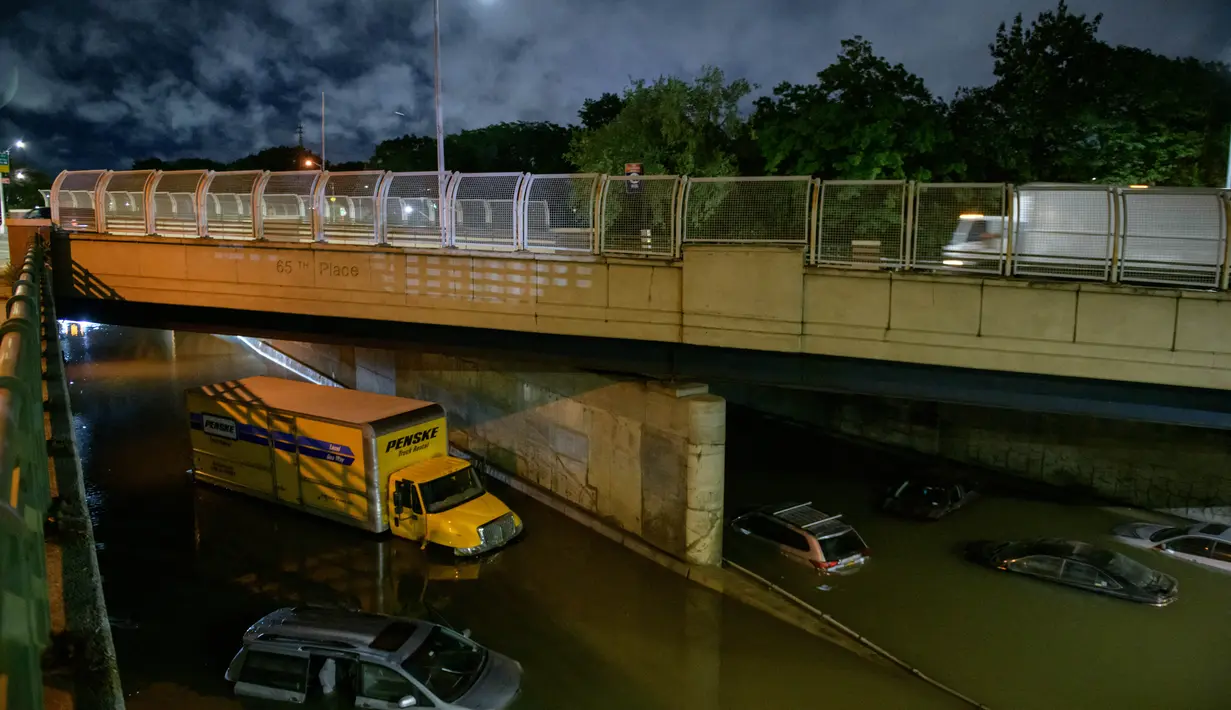 Sejumlah mobil terjebak banjir yang merendam jalanan di Brooklyn, New York, Amerika Serikat, Kamis (2/9/2021). Banjir bandang terjadi di sejumlah titik di pusat kota New York setelah hujan lebat yang dipicu Badai Ida mengguyur kota tersebut. (AFP/Ed Jones)