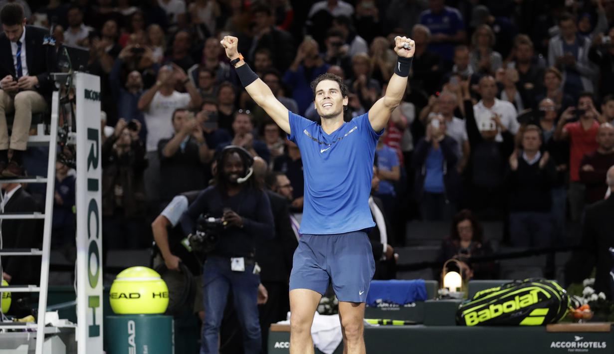 Petenis Spanyol, Rafael Nadal berselebrasi seusai mengalahkan petenis Korea Selatan, Hyeon Chung pada babak kedua Paris Masters di Paris, Rabu (1/11). Nadal sukses mengunci peringkat satu dunia pada akhir tahun 2017. (CHRISTOPHE ARCHAMBAULT / AFP)