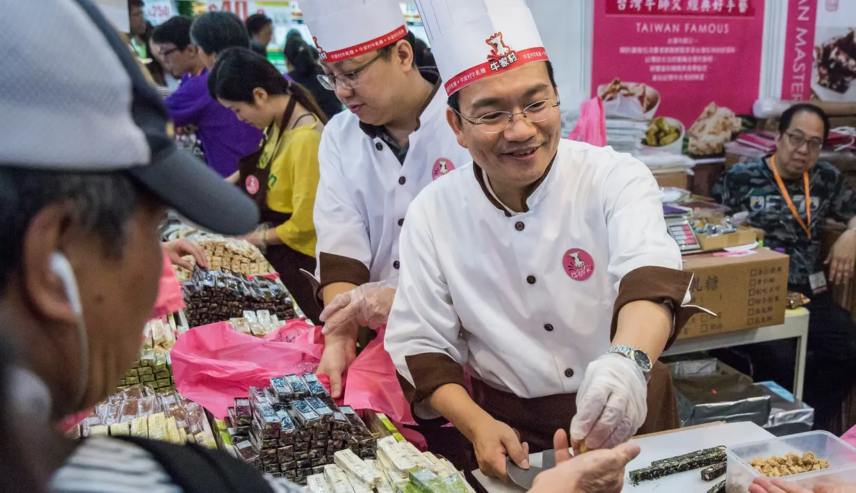 Penjual melayani pengunjung selama Food Expo di Hong Kong (19/8). Pameran makanan tahunan ini diadakan di Hong Kong Exhibition and Convention Center dan berlangsung dari 17-21 Agustus. (AFP Photo/Isaac Lawrence)