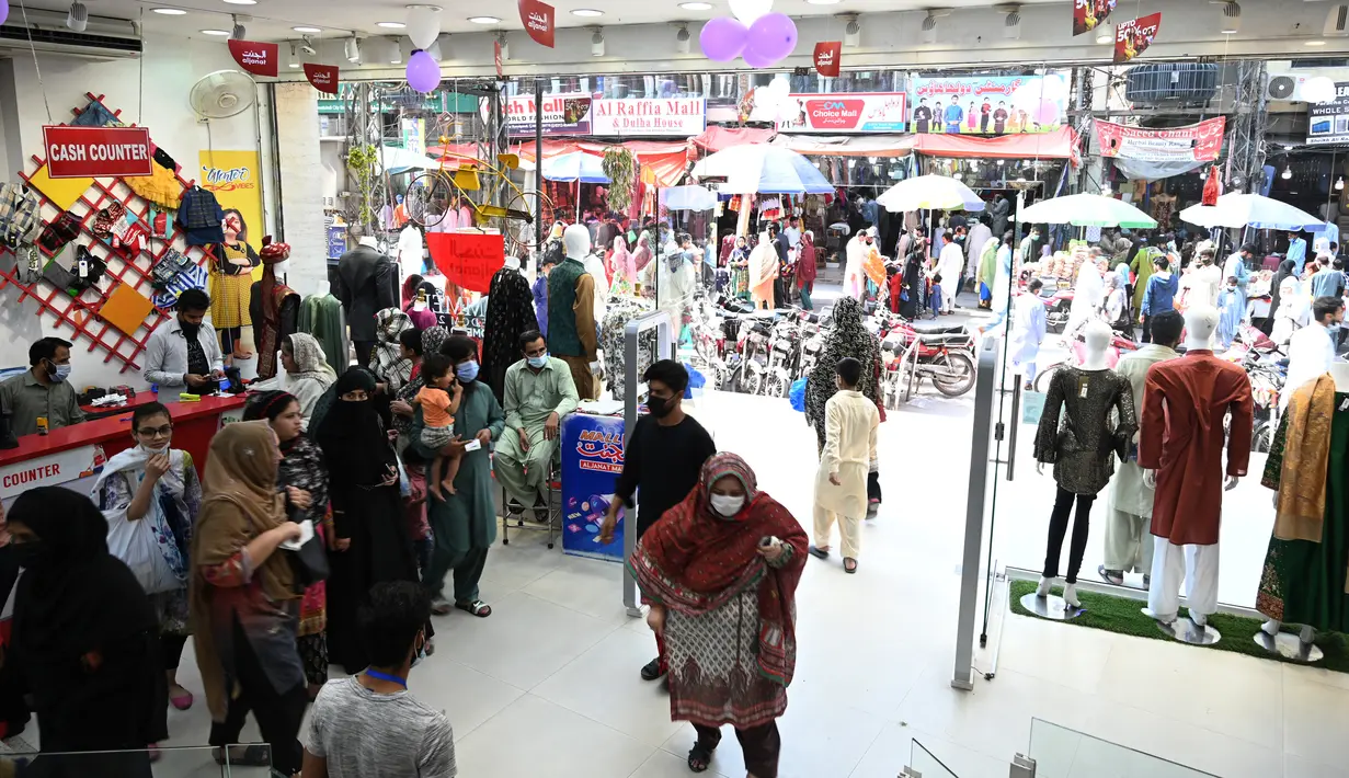 Orang-orang memadati toko saat berbelanja menjelang perayaan Idul Fitri yang akan datang di tengah pandemi corona Covid-19, di Rawalpindi, Pakistan pada 5 Mei 2021. Pusat perbelanjaan ramai oleh warga Pakistan yang berbelanja aneka kebutuhan untuk menyambut Lebaran. (Farooq NAEEM / AFP)