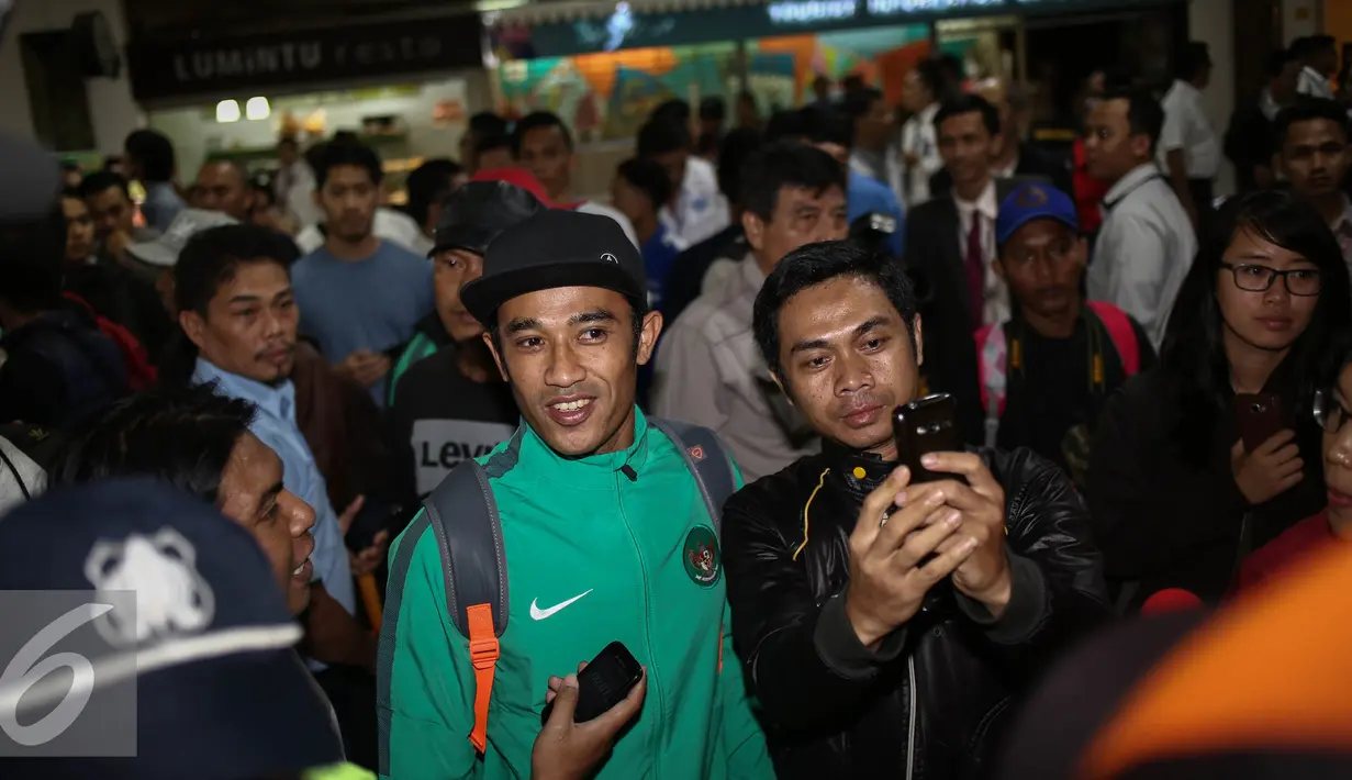 Masyarakat berselfie dengan pemain tim nasional saat tiba di Bandara Soekarno Hatta, Jakarta, Kamis (8/12). Setelah menahan imbang Vietnam pada semifinal Piala AFF 2016, Timnas pulang membawa kemenangan untuk Indonesia. (Liputan6.com/Faizal Fanani)