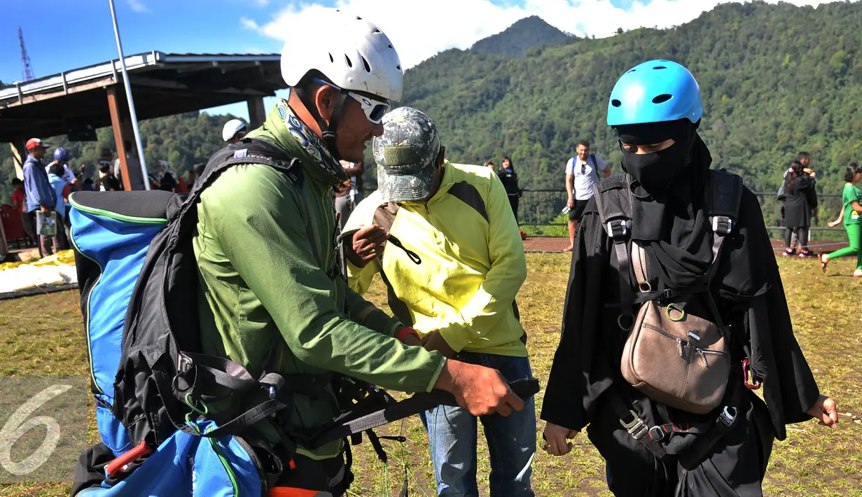 Pengunjung saat bersiap terbang dengan Paralayang di Puncak Pass, Bogor, Jumat (6/4). Olahraga yang memacu adrenalin ini dipatok dengan harga Rp. 350 Ribu. (Liputan6.com/Johan Tallo)