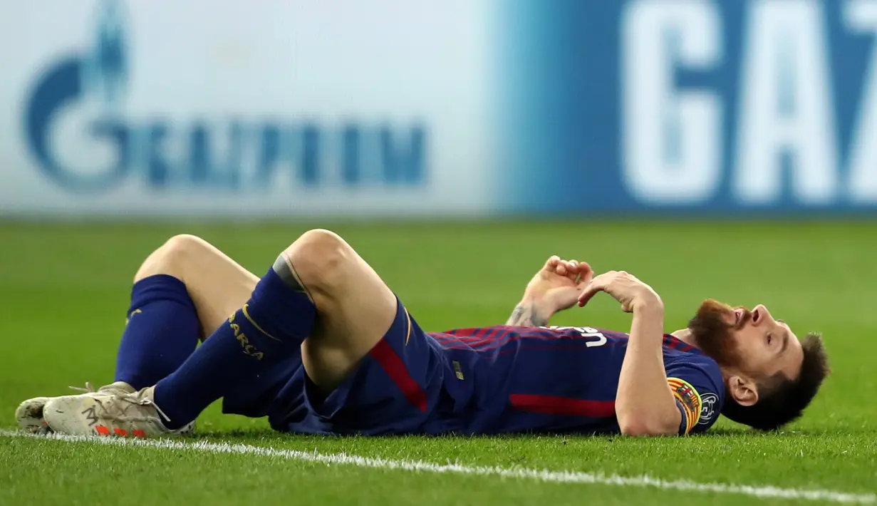 Pemain Barcelona, Lionel Messi tergeletak di lapangan disela-sela laga babak penyisihan Grup D Liga Champions melawan Olympiakos di Georgios Karaiskáki, Rabu (1/11). Barcelona hanya mampu bermain imbang dengan skor 0-0. (AP/Thanassis Stavrakis)