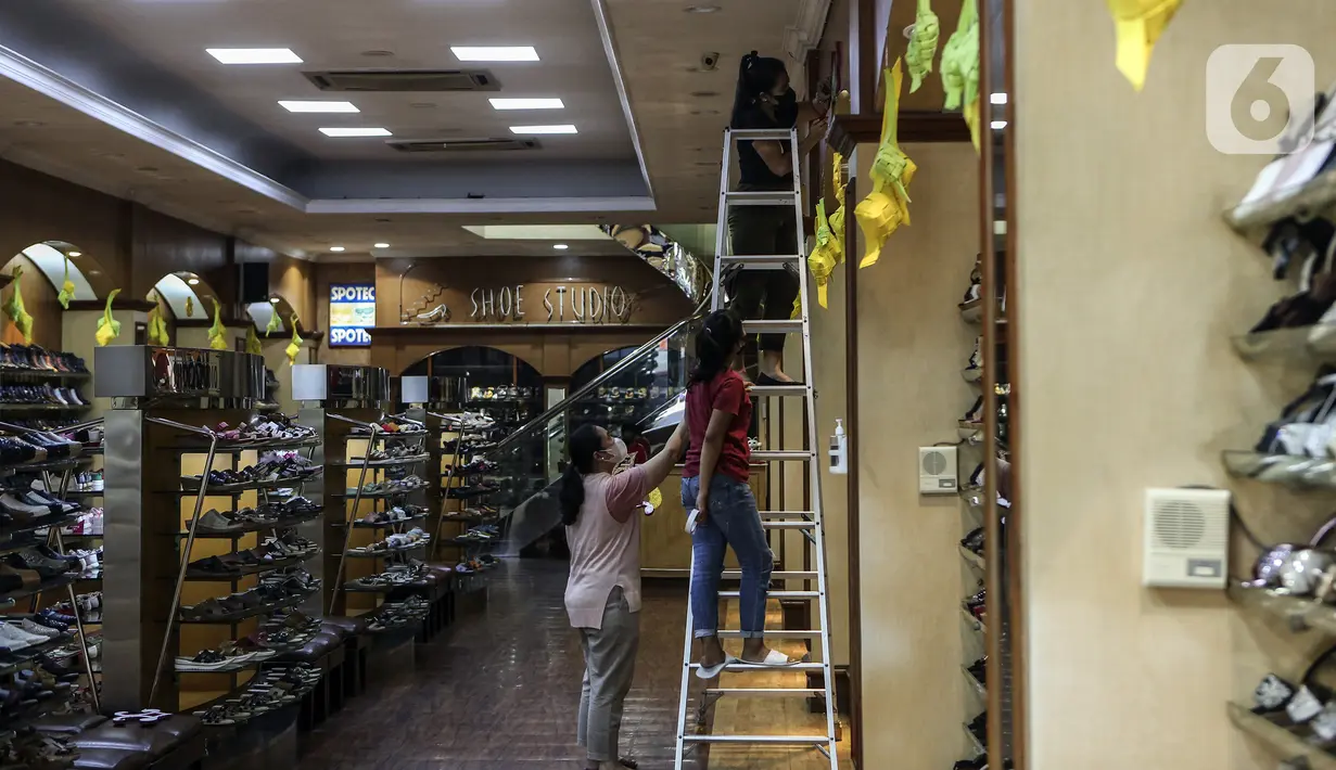 Karyawan memasang ornamen untuk mempercantik toko jelang bulan suci Ramadhan di Pasar Baru, Jakarta, Rabu (9/3/2022). Selain untuk mempercantik toko, pemasangan ornamen juga untuk menarik perhatian pengunjung atau warga yang hendak berbelanja ke toko tersebut. (Liputan6.com/Johan Tallo)