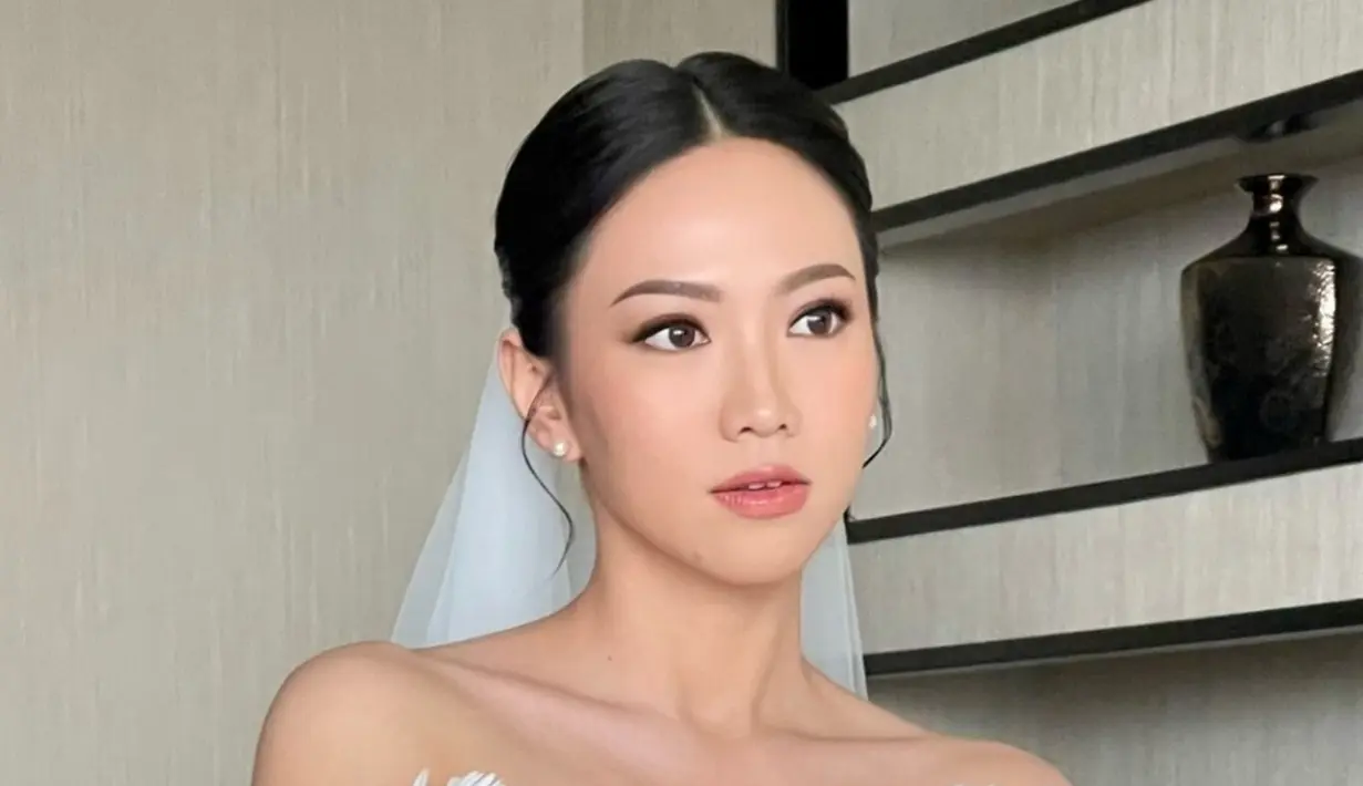 Inilah potret gaun serba putih yang dikenakan Shanju saat melakukan pemberkatan. Didesain oleh Elsie Chrysila Atelier, bunga di atas gaun terlihat eksklusif. Lain daripada yang lain, gaun pernikahan Shanju banir pujian. (Liputan6.com/IG/@tirzavania)