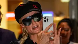 Selebritas Amerika Serikat Paris Hilton berfoto dengan ponselnya saat tiba di Bandara Internasional Chhatrapati Shivaji, Mumbai, India, 19 Oktober 2022. Dia terlihat mengenakan jaket ritsleting beludru hitam dengan celana olahraga yang serasi. (AP Photo/Rafiq Maqbool)