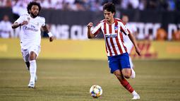 Gelandang Atletico Madrid, Joao Felix menggiring bola dari kejaran bek Real Madrid, Marcelo selama laga International Champions Cup 2019 di Arena Stadium Metlife, New Jersey (27/7/2019). (AFP Photo/Johannes Eisele)