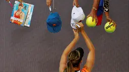Petenis putri Rusia, Maria Sharapova, memberikan tanda tangan kepada penggemar setelah bertanding melawan petenis Swiss, Belinda Bencic, di babak keempat tenis Australia Terbuka 2016 di Melbourne Park, Australia, (24/1/2016). (Reuters/Thomas Peter)