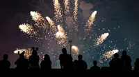 Warga menyaksikan pertunjukan kembang api pada perayaan Hari Kemerdekaan Amerika Serikat di sisi timur Manhattan, Rabu (4/7).  AS merayakan hari kemerdekaan yang jatuh pada 4 Juli atau dikenal sebagai Independence Day 4th July. (AP/Craig Ruttle)
