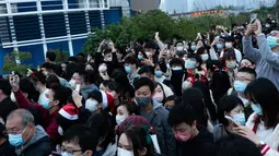 Orang-orang mengambil foto pohon Natal raksasa selama Natal di distrik budaya West Kowloon di Hong Kong (25/12/2021). Pohon Natal raksasa didekorasi secara glamor dengan karangan bunga dan ornamen, berkilauan dengan lampu meriah yang cerah. (AFP/Bertha Wang)