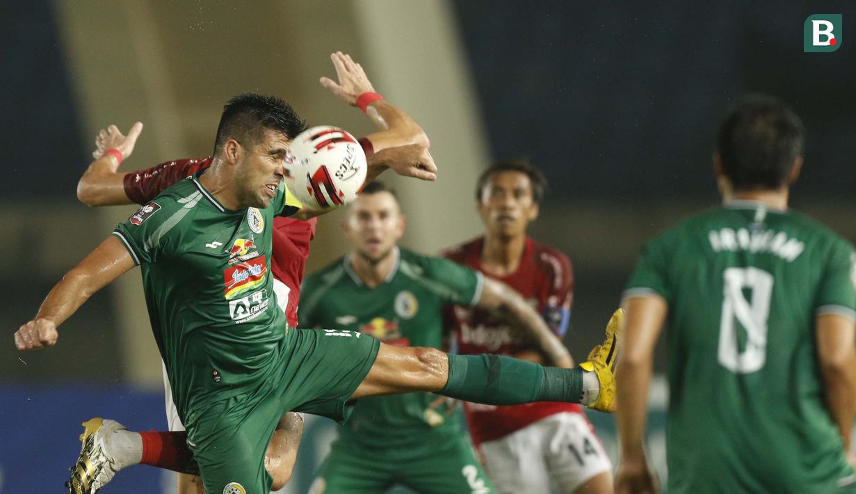 Bek PSS Sleman, Fabiano Beltrame (kiri depan) berebut bola dengan striker Bali United, Ilja Spasojevic dalam laga perempatfinal Piala Menpora 2021 di Stadion Si Jalak Harupat, Bandung, Senin (12/4/2021). PSS Sleman menang 4-2 melalui adu penalti. (Bola.com/Ikhwan Yanuar)