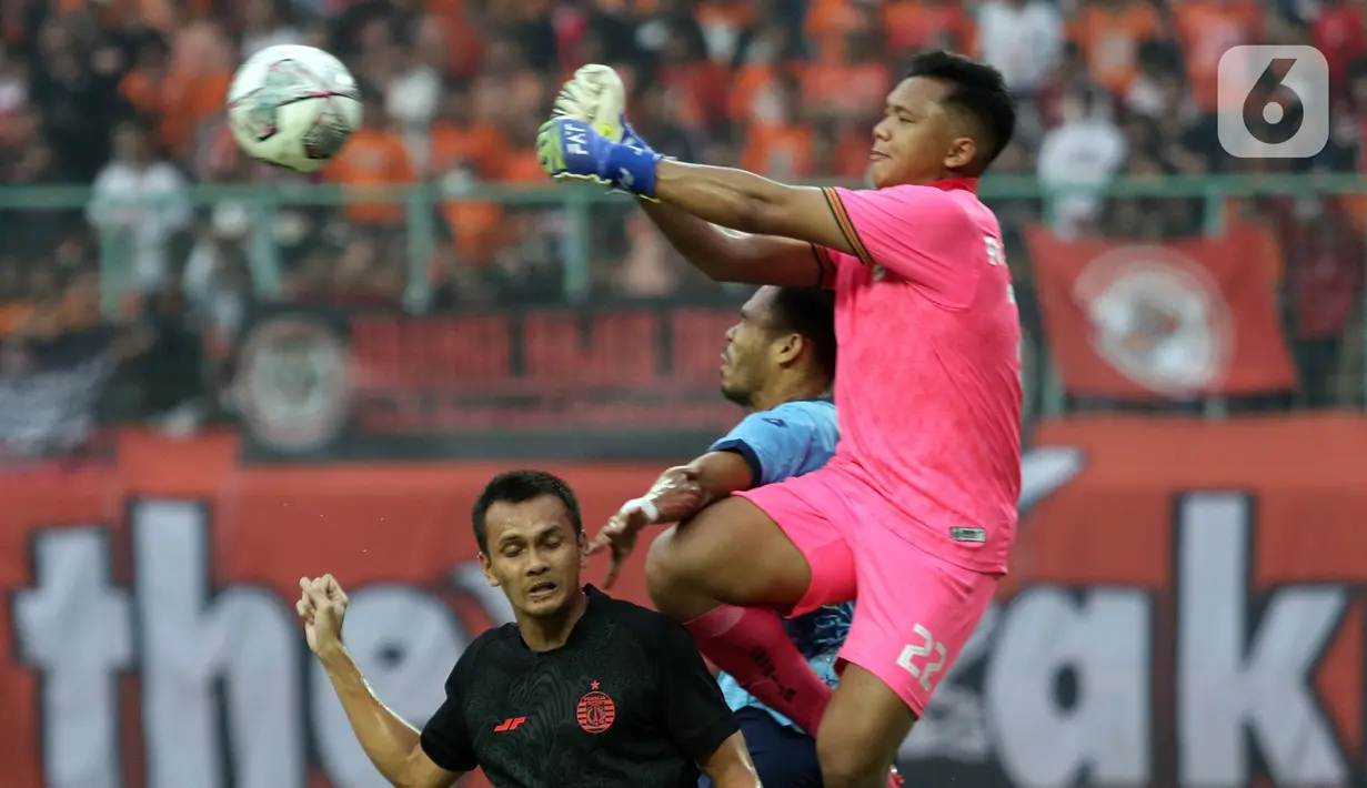 Penjaga gawang Persija, Rizky Muhammad Sudirman (kanan) berebut bola atas dengan pemain Sabah FC pada laga uji coba internasional di Stadion Patriot Candrabhaga, Kota Bekasi, Minggu (5/6/2022). Persija kalah 1-2 dari Sabah FC. (Liputan6.com/Helmi Fithriansyah)