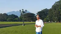 Dengan mengenakan kemeja putih dan sarung kotak-kotak berwarna biru, Jokowi tampak santai menyaksikan gerhana matahari di halaman Istana Bogor, Rabu (9/3). (facebook.com/Jokowi)