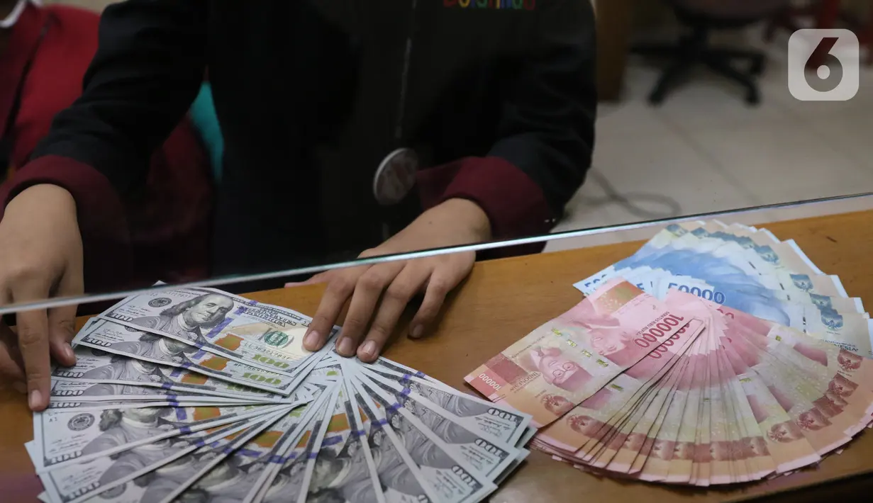 Petugas menunjukkan mata uang rupiah dan dolar di Jakarta, Senin (9/11/2020). Rupiah dibuka di angka 14.172 per dolar AS, menguat jika dibandingkan dengan penutupan perdagangan sebelumnya yang ada di angka 14.210 per dolar AS. (Liputan6.com/Angga Yuniar)