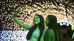 Dua wanita berfoto selfie di acara lampu Natal di taman Ibirapuera di Sao Paulo, Brasil, Selasa (14/12/2021). Jelang perayaan Natal, taman dan pantai dihiasi lampu-lampu yang indah. (AP Photo/Andre Penner)