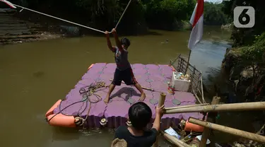 Anak-anak menggunakan perahu eretan di sungai Ciliwung, Jakarta, Selasa (3/11/2020). Perahu eretan di sungai Ciliwung masih bertahan sebagai penghubung Jakarta Timur dan Jakarta Selatan Selatan. (merdeka.com/Imam Buhori)